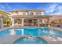 Backyard featuring a sparkling pool, spa, covered patio, and comfortable seating areas at 5455 San Florentine Ave, Las Vegas, NV 89141