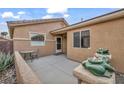 Private courtyard area featuring decorative frog sculptures, seating area, and a secure front entrance at 5697 Crowbush Cove Pl, Las Vegas, NV 89122