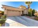 Tan house with a two-car garage and well-maintained landscaping at 7387 Howell Mill Ct, Las Vegas, NV 89113