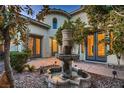 Elegant front courtyard featuring a fountain and lush landscaping at 7501 Midnight Rambler St, Las Vegas, NV 89149