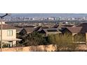 View of Las Vegas skyline from neighborhood featuring modern homes with solar panels, and desert landscaping at 12381 Foxtail Run Ave, Las Vegas, NV 89138