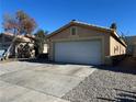 Front view of a house with a white garage door and gravel driveway at 1420 Arlington Heights St, Las Vegas, NV 89110