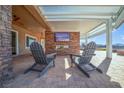 Relaxing patio with seating and fireplace under pergola at 1645 Warrington Dr, Henderson, NV 89052