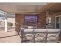 Covered patio with seating and an outdoor fireplace at 1645 Warrington Dr, Henderson, NV 89052