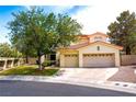 Two-story house with attached two-car garage and lush landscaping in front at 1813 Francisco Peak Pl, Las Vegas, NV 89128