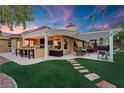 Outdoor kitchen and dining area with pergola and artificial turf at 2228 Lucerne Ct, Henderson, NV 89014