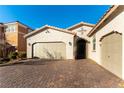 Two-car garage, paver driveway, and front entrance with decorative iron door at 3158 Biancavilla Ave, Henderson, NV 89044