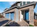 Modern home with a three-car garage and blue front door at 358 Terrill Ave, Las Vegas, NV 89183