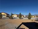 Single-story yellow house with a garage and covered parking area at 3720 W Charleston Park Ave, Pahrump, NV 89048