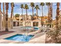 Community pool and spa with lounge chairs and palm trees at 6861 Tamarus St # 203, Las Vegas, NV 89119