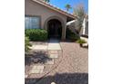 Front entry with walkway, arched entryway and mature shrubs at 7509 W Gilmore Ave, Las Vegas, NV 89129