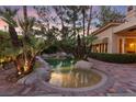 Backyard oasis featuring a lagoon style pool with rock accents and mature palms, creating a private retreat at 8199 Pinnacle Peak Ave, Las Vegas, NV 89113