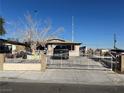 Single-story house with gated driveway and mature tree in front at 1152 Miller Ave, Las Vegas, NV 89106