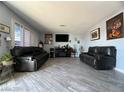 Spacious living room with gray tile floors and black reclining sofas at 1152 Miller Ave, Las Vegas, NV 89106