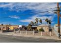 Quaint home with a charming front yard, mature palm trees, and desert-style landscaping at 132 Continental Ave, Henderson, NV 89015