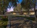 Single story home with a long driveway and landscaping at dusk at 2800 Ashby Ave, Las Vegas, NV 89102