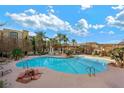 Inviting community pool with palm trees and a shaded seating area at 30 Strada Di Villaggio # 207, Henderson, NV 89011