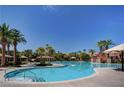 Resort-style pool surrounded by palm trees and shaded lounge areas for ultimate relaxation at 334 Sea Rim Ave, Las Vegas, NV 89148