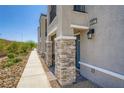 Townhome exterior featuring stacked stone accents, well manicured landscaping, and walkway at 6521 Taffrail Ave, Las Vegas, NV 89118