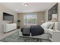 Cozy bedroom with a large window, TV, modern dresser and soft, inviting bedding at 7659 Dewy Falls Ave, Las Vegas, NV 89179