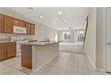 Open kitchen design with granite countertops, tile flooring and bright, airy space at 7659 Dewy Falls Ave, Las Vegas, NV 89179