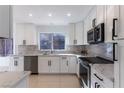 Modern white kitchen with quartz countertops and stainless steel appliances at 8913 Stoney Point Dr, Las Vegas, NV 89134