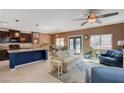 Open concept kitchen and living area with dark cabinets, granite counters, and blue island at 9417 Sand Tiger Ave, Las Vegas, NV 89148