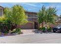 Inviting two-story home boasts lush trees, brick accents and a convenient two-car garage at 10273 Aragon Crown Rd, Las Vegas, NV 89135
