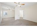 Bright main bedroom with large mirrored closet, ceiling fan, and neutral carpet at 10280 Gilmore Canyon Ct # 203, Las Vegas, NV 89129