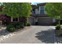 Paver driveway leading to a three-car garage, flanked by lush landscaping at 4450 Palisades Canyon Cir, Las Vegas, NV 89129