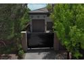 Three-car garage accessible through a black iron security gate on a private street at 4450 Palisades Canyon Cir, Las Vegas, NV 89129