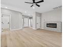 Spacious living room featuring a modern fireplace and light hardwood floors at 511 Dalgreen Pl, Henderson, NV 89012