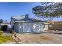 Exterior view of a house with a two-car garage and driveway at 6008 Carmel Way, Las Vegas, NV 89108