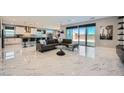 Open-concept living space with marble floors, large glass doors, and modern furnishings at 6834 Compass St, North Las Vegas, NV 89084