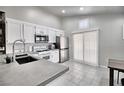 Modern kitchen with concrete countertops, stainless steel appliances, and white cabinets at 8836 Big Bear Pines Ave, Las Vegas, NV 89143