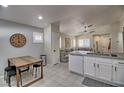 Open concept kitchen with white cabinets, concrete countertops, and eat-in area at 8836 Big Bear Pines Ave, Las Vegas, NV 89143