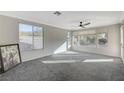 Bright and airy living room with large windows and neutral carpeting at 10201 Premia Pl, Las Vegas, NV 89135