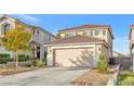 Two-story house with tan siding, attached garage, and landscaped yard at 1129 Majestic Canyon St, Henderson, NV 89052