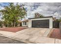 Front view of a remodeled home with red door and dark garage door at 145 Hancock St, Las Vegas, NV 89110