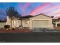 Tan house with beige garage door and landscaped yard at 2540 Sparrow Way, Pahrump, NV 89048