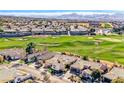 Aerial view showcasing a house on a golf course with mountain backdrop at 2589 Sumter St, Henderson, NV 89052