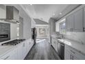 Beautiful kitchen features stainless steel appliances, marble countertops, and a modern range hood at 5236 Woodlawn Ln, Las Vegas, NV 89130