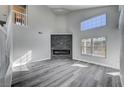 Bright living room features high ceilings, gray flooring, modern fireplace, and abundant natural light at 5236 Woodlawn Ln, Las Vegas, NV 89130