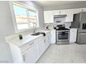 Modern kitchen with white cabinets and stainless steel appliances at 5260 San Anselmo St, Las Vegas, NV 89120