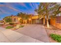 Front view of a luxurious home with a large driveway and mature trees at 59 Portezza Dr, Henderson, NV 89011