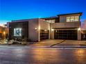 Contemporary home showcasing a sleek design, modern garage doors, and minimalist landscaping at 591 Overlook Rim Dr, Henderson, NV 89012