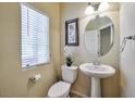 Small powder room with pedestal sink, toilet and decorative accents at 5993 Lambert Bridge Ave, Las Vegas, NV 89139