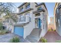 Two-story home with gray siding, blue door, and a stone stairway at 7075 Jasper Hill Way, Las Vegas, NV 89118