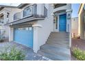 Two-story home with gray siding, blue door, and a stone stairway at 7075 Jasper Hill Way, Las Vegas, NV 89118