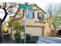 Two-story house with beige exterior, two-car garage, and landscaping at 7529 Earnshaw Ave, Las Vegas, NV 89149